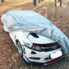 car protection cover in gray over white car