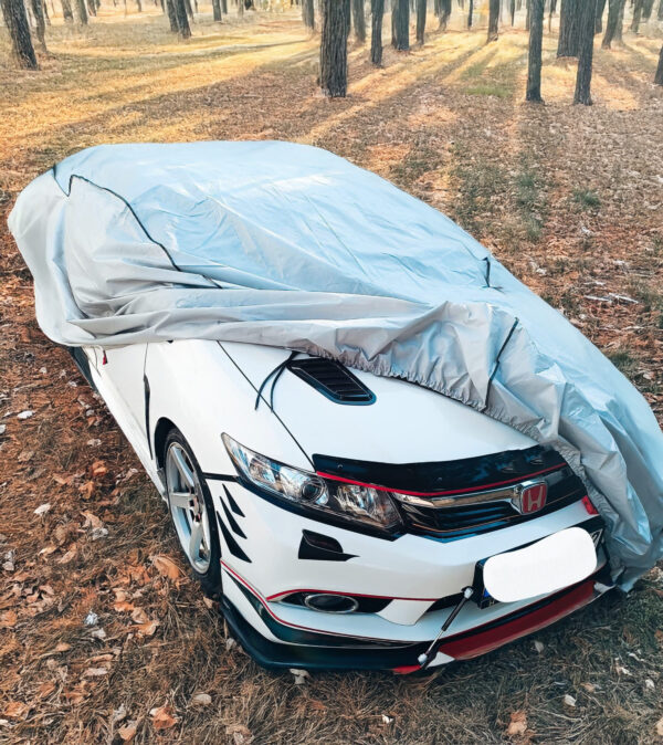 car protection cover in gray over white car
