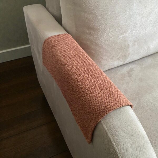 Decorative tan couch armrest protector styled on two-seater sofa