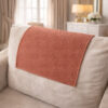 Elegan tan color fleece sofa cover placed on the headrest of white couch