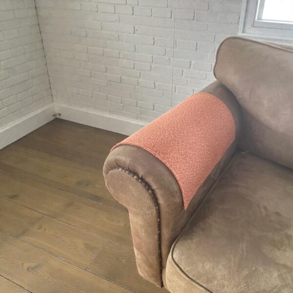 Decorative tan couch armrest overlay in warm interior setting